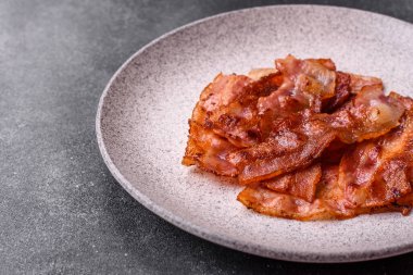 Fried pork bacon slices or strips as a breakfast ingredient. Fried bacon as a food background for your design