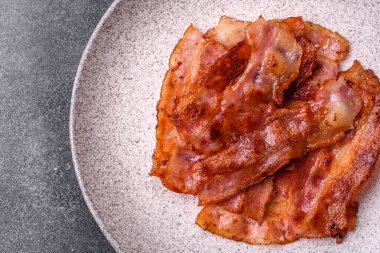 Fried pork bacon slices or strips as a breakfast ingredient. Fried bacon as a food background for your design