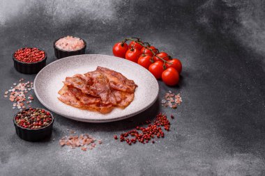 Fried pork bacon slices or strips as a breakfast ingredient. Fried bacon as a food background for your design