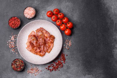 Fried pork bacon slices or strips as a breakfast ingredient. Fried bacon as a food background for your design