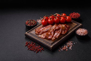 Fried pork bacon slices or strips as a breakfast ingredient. Fried bacon as a food background for your design