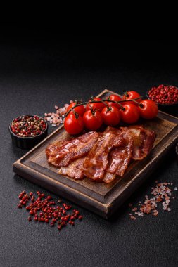 Fried pork bacon slices or strips as a breakfast ingredient. Fried bacon as a food background for your design