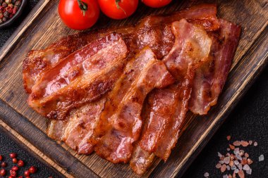 Fried pork bacon slices or strips as a breakfast ingredient. Fried bacon as a food background for your design