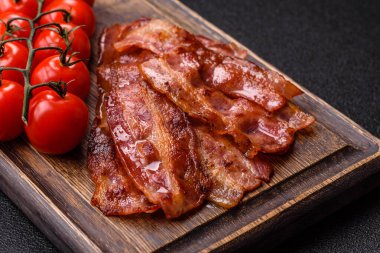 Fried pork bacon slices or strips as a breakfast ingredient. Fried bacon as a food background for your design
