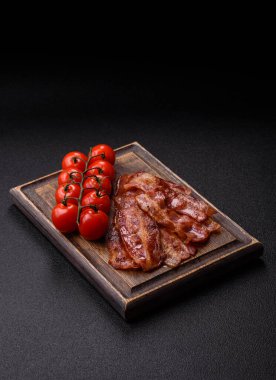 Fried pork bacon slices or strips as a breakfast ingredient. Fried bacon as a food background for your design