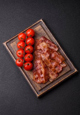 Fried pork bacon slices or strips as a breakfast ingredient. Fried bacon as a food background for your design