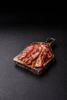 Fried pork bacon slices or strips as a breakfast ingredient. Fried bacon as a food background for your design