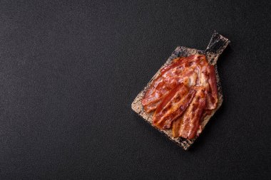 Fried pork bacon slices or strips as a breakfast ingredient. Fried bacon as a food background for your design