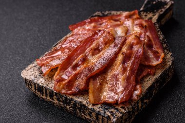 Fried pork bacon slices or strips as a breakfast ingredient. Fried bacon as a food background for your design