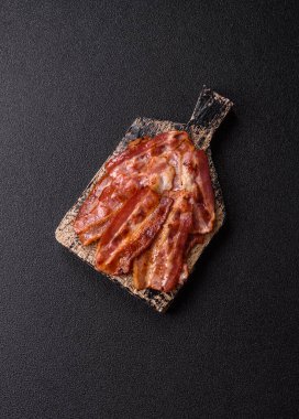 Fried pork bacon slices or strips as a breakfast ingredient. Fried bacon as a food background for your design