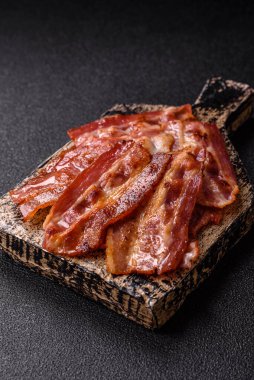 Fried pork bacon slices or strips as a breakfast ingredient. Fried bacon as a food background for your design