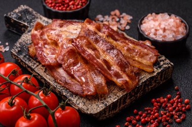 Fried pork bacon slices or strips as a breakfast ingredient. Fried bacon as a food background for your design