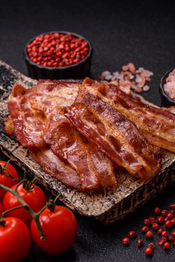 Fried pork bacon slices or strips as a breakfast ingredient. Fried bacon as a food background for your design
