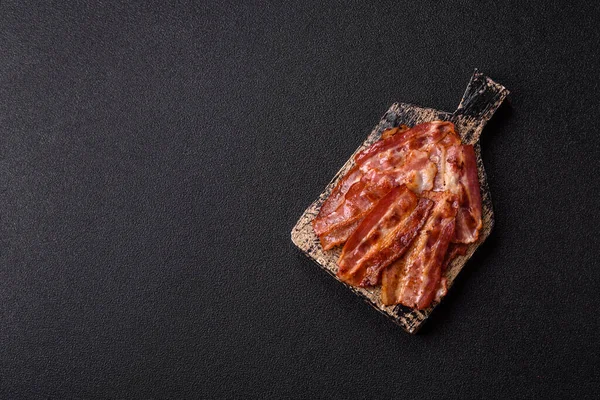 Fried pork bacon slices or strips as a breakfast ingredient. Fried bacon as a food background for your design