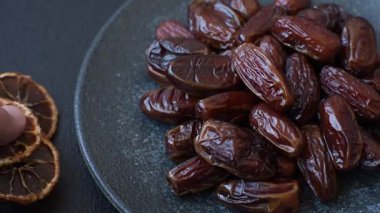 Seramik tabakta kurutulmuş hurmalar, ramazan tabağı için Arapça yiyecekler. Kurumuş tarihler tasarımın için bir yemek arkaplanı olarak kullanılacak..