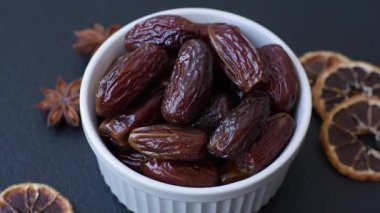 Seramik tabakta kurutulmuş hurmalar, ramazan tabağı için Arapça yiyecekler. Kurumuş tarihler tasarımın için bir yemek arkaplanı olarak kullanılacak..