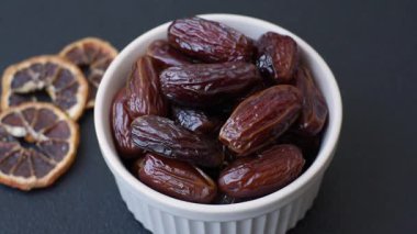 Seramik tabakta kurutulmuş hurmalar, ramazan tabağı için Arapça yiyecekler. Kurumuş tarihler tasarımın için bir yemek arkaplanı olarak kullanılacak..