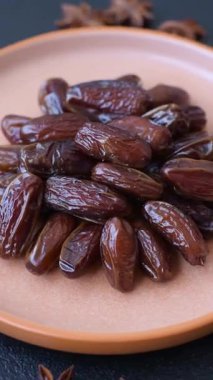 Seramik tabakta kurutulmuş hurmalar, ramazan tabağı için Arapça yiyecekler. Kurumuş tarihler tasarımın için bir yemek arkaplanı olarak kullanılacak..