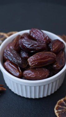 Seramik tabakta kurutulmuş hurmalar, ramazan tabağı için Arapça yiyecekler. Kurumuş tarihler tasarımın için bir yemek arkaplanı olarak kullanılacak..