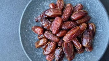 Seramik tabakta kurutulmuş hurmalar, ramazan tabağı için Arapça yiyecekler. Kurumuş tarihler tasarımın için bir yemek arkaplanı olarak kullanılacak..