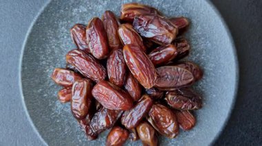 Seramik tabakta kurutulmuş hurmalar, ramazan tabağı için Arapça yiyecekler. Kurumuş tarihler tasarımın için bir yemek arkaplanı olarak kullanılacak..