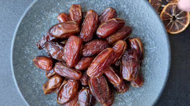 Seramik tabakta kurutulmuş hurmalar, ramazan tabağı için Arapça yiyecekler. Kurumuş tarihler tasarımın için bir yemek arkaplanı olarak kullanılacak..