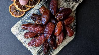 Seramik tabakta kurutulmuş hurmalar, ramazan tabağı için Arapça yiyecekler. Kurumuş tarihler tasarımın için bir yemek arkaplanı olarak kullanılacak..