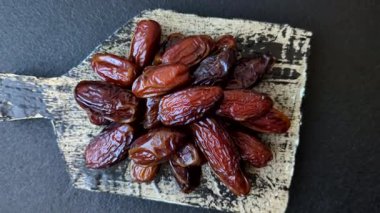 Seramik tabakta kurutulmuş hurmalar, ramazan tabağı için Arapça yiyecekler. Kurumuş tarihler tasarımın için bir yemek arkaplanı olarak kullanılacak..