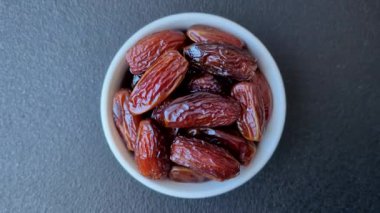Seramik tabakta kurutulmuş hurmalar, ramazan tabağı için Arapça yiyecekler. Kurumuş tarihler tasarımın için bir yemek arkaplanı olarak kullanılacak..