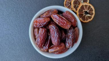 Seramik tabakta kurutulmuş hurmalar, ramazan tabağı için Arapça yiyecekler. Kurumuş tarihler tasarımın için bir yemek arkaplanı olarak kullanılacak..