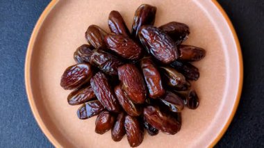 Seramik tabakta kurutulmuş hurmalar, ramazan tabağı için Arapça yiyecekler. Kurumuş tarihler tasarımın için bir yemek arkaplanı olarak kullanılacak..