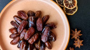 Seramik tabakta kurutulmuş hurmalar, ramazan tabağı için Arapça yiyecekler. Kurumuş tarihler tasarımın için bir yemek arkaplanı olarak kullanılacak..