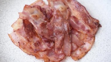 Fried pork bacon slices or strips as a breakfast ingredient. Fried bacon as a food background for your design