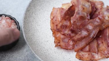 Fried pork bacon slices or strips as a breakfast ingredient. Fried bacon as a food background for your design