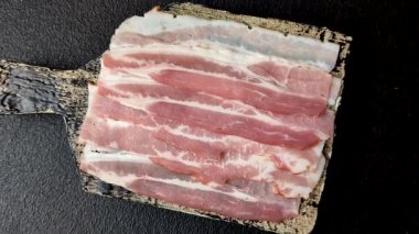 Raw or smoked pork bacon slices or strips as a breakfast ingredient. Raw bacon as a food background for your design.