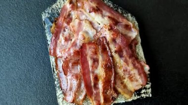 Fried pork bacon slices or strips as a breakfast ingredient. Fried bacon as a food background for your design