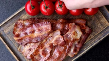 Fried pork bacon slices or strips as a breakfast ingredient. Fried bacon as a food background for your design