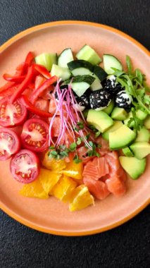 Somon parçaları, peynir, domates, biber ve avokado ile kase. Tasarımınız için arka plan olarak somon kasesi