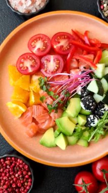 Somon parçaları, peynir, domates, biber ve avokado ile kase. Tasarımınız için arka plan olarak somon kasesi