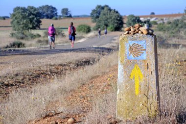 St. James Camino de Santiago 'nun yolu, İspanya' nın Galiçya kentindeki Compostela Katedrali 'ne hacılar için deniz kabuğu işaretleri imzalamak. Sırt çantalı hacılar hac yolunda yürüyorlar.
