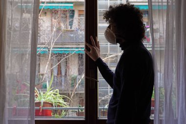 Evin içinde duran maskeli adam. 