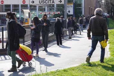 İtalya, Milan - Mart 2020 - Maskeli ve maskesiz insanlar Esselunga, n-cov19 Coronavirus acil servisine bir metre uzaklıktalar - çok fazla insan evi terk ediyor