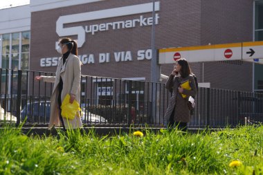 İtalya, Milan - Mart 2020 - Maskeli ve maskesiz insanlar Esselunga, n-cov19 Coronavirus acil servisine bir metre uzaklıktalar - çok fazla insan evi terk ediyor