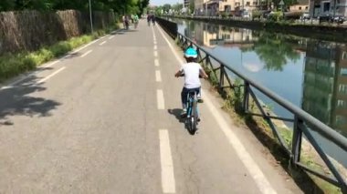 Parkta bisiklet süren küçük bir çocuk.