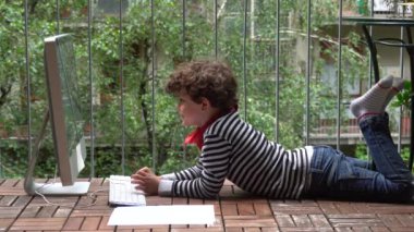 Çocuk salgın sırasında evde bilgisayar kullanıyor. 