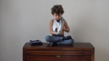 Evde tişört giyen bir çocuk. 