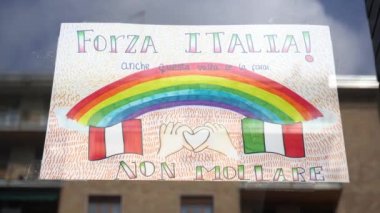 Avrupa, İtalya, Milano - Mart 2020: Ani kalabalık, çocuklar ve aileler gökkuşağı ve scirtta çiziyor. Ev pencerelerinde her şey iyi gidecek - Salgın acil durum n-cov19 Coronavirus