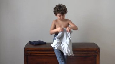 Evde tişört giyen bir çocuk. 