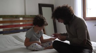 Baba ve oğul el dezenfektanı kullanıyor.