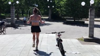 Parkta egzersiz yapan genç kadın.